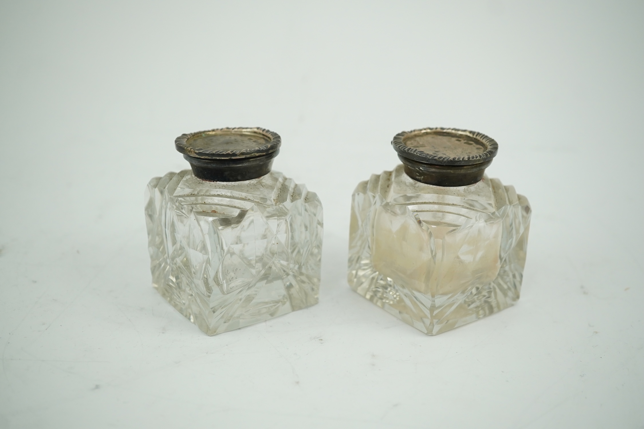 A pair of silver mounted cut glass inkwells, maker JT, height 66mm. Condition - fair to good